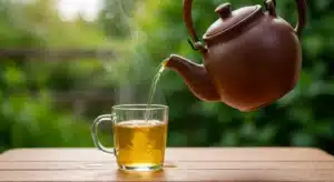 Natural Zepbound recipe drink steeping in a clear glass mug on a rustic wooden table with golden glow.